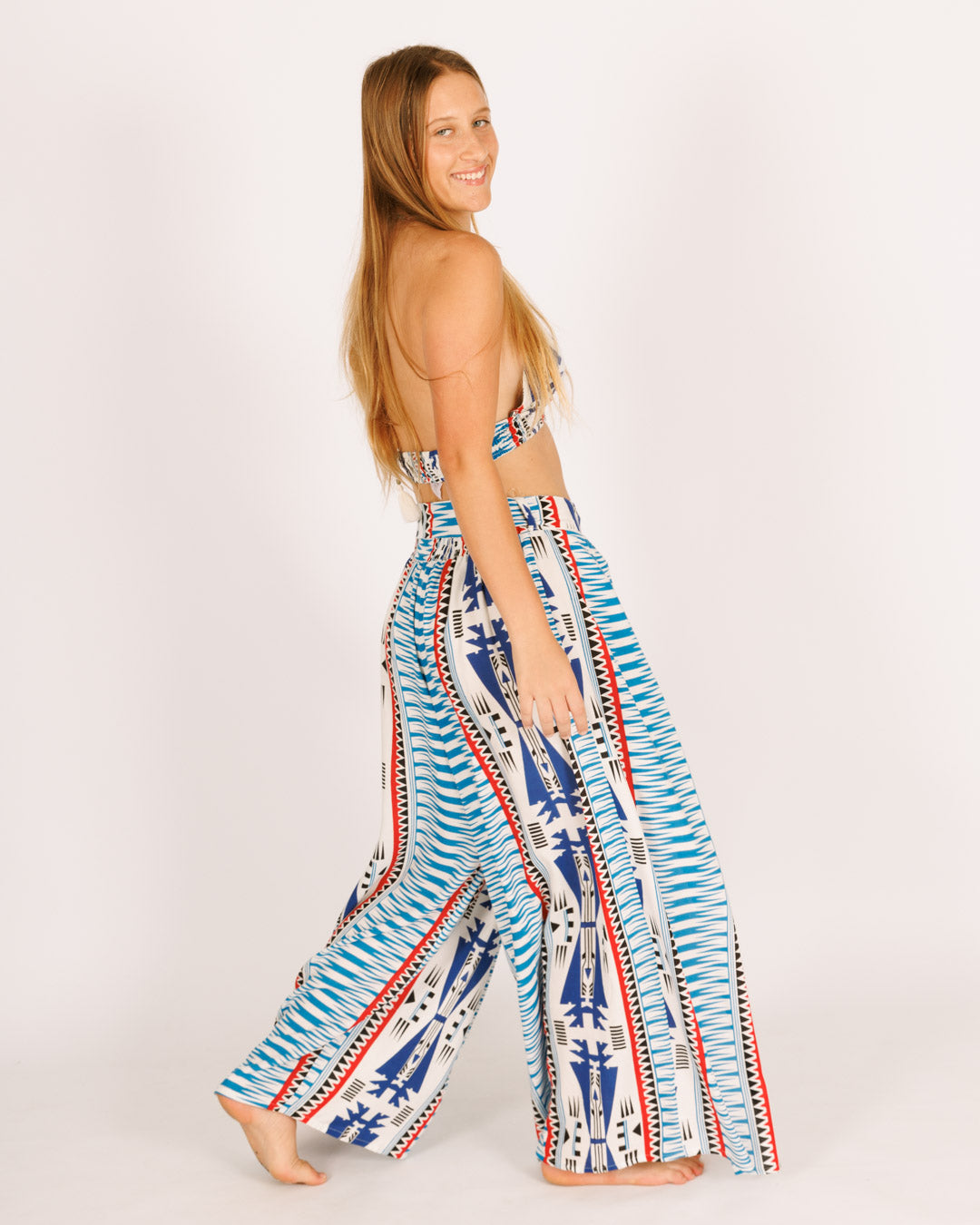 Long viscose trousers, white with blue tribal stripes, featuring slits.