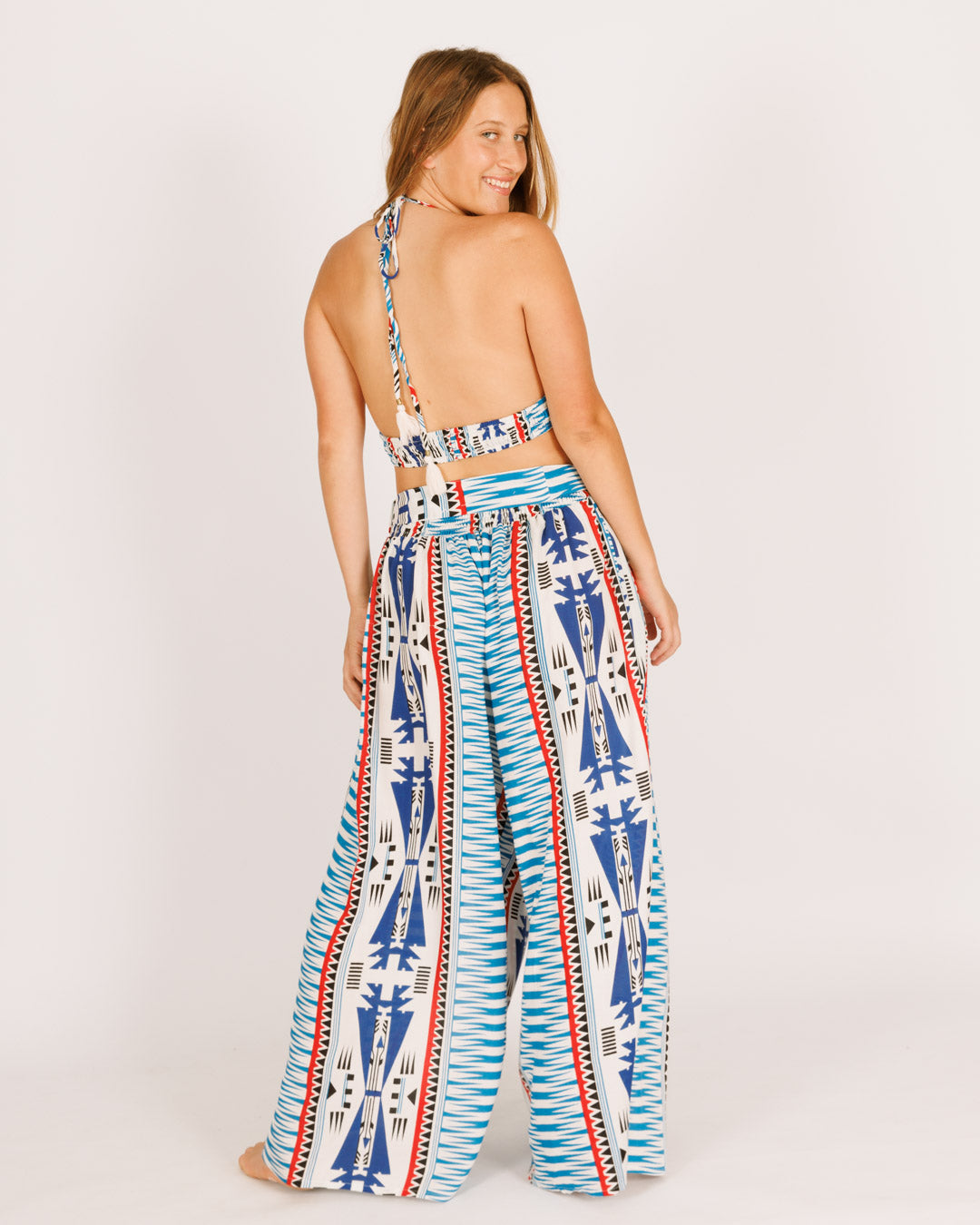 Long viscose trousers, white with blue tribal stripes, featuring slits.